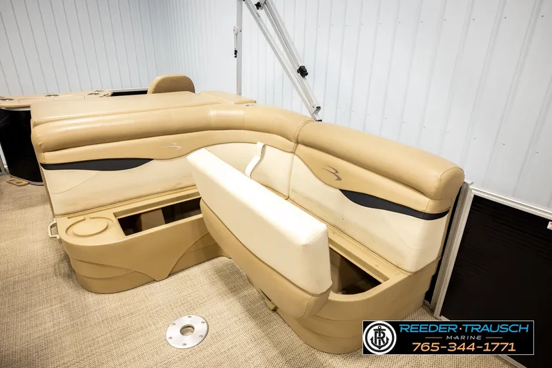 Slide: The Image of 2018 Bennington SX RF boat interior with beige seating and storage compartments. - 24
