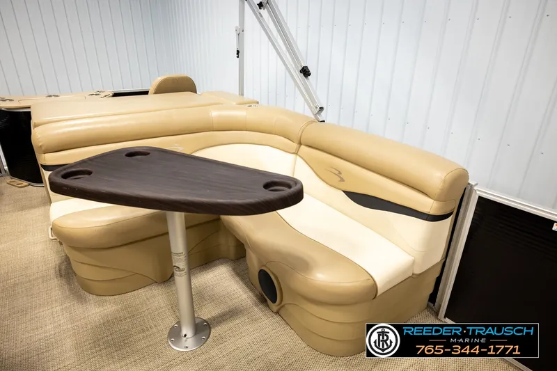 Slide: The Image of 2018 Bennington SX RF boat interior with beige seating and a dark wood table. - 23