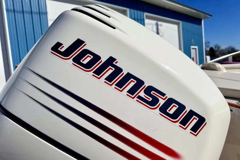 Slide: The Image of 2003 Glastron GX 180 Ski & Fish with Johnson outboard motor, blue building background. - 16