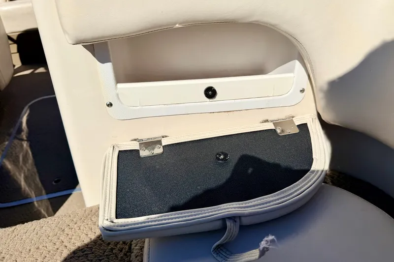 Slide: The Image of 2003 Glastron GX 180 Ski & Fish boat storage compartment with open lid, beige interior. - 55