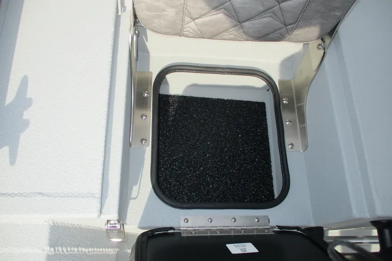 Slide: The Image of Avid 20 Rogue CC 2027 boat storage compartment with cushioned seat and metal hinges. - 9