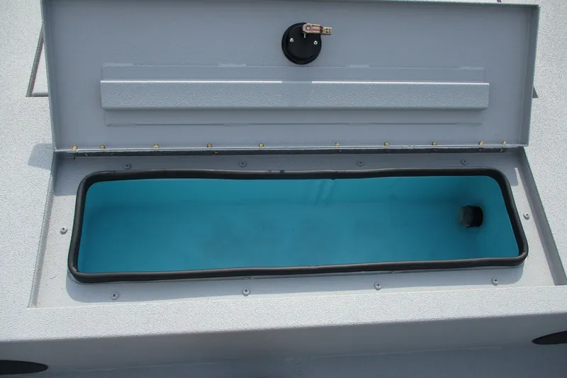 Slide: The Image of Open storage compartment in 2027 Avid 20 Rogue CC boat, featuring a blue interior. - 6