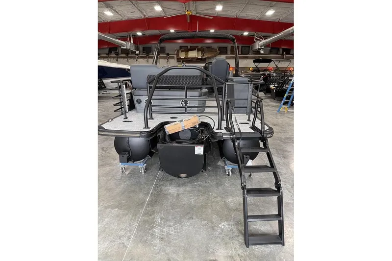 Slide: The Image of 2026 Sylvan L-5 Platnum pontoon boat in showroom, featuring sleek design and sturdy ladder. - 3