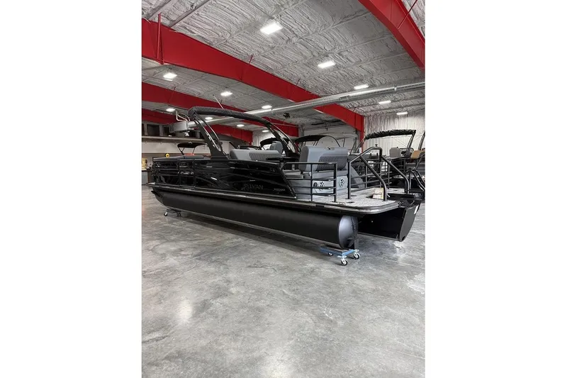 Slide: The Image of 2026 Sylvan L-5 Platinum pontoon boat in showroom, featuring sleek black design. - 2