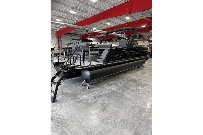 Slide: The Image of 2026 Sylvan L-5 Platinum pontoon boat in a showroom with red ceiling accents. - 4