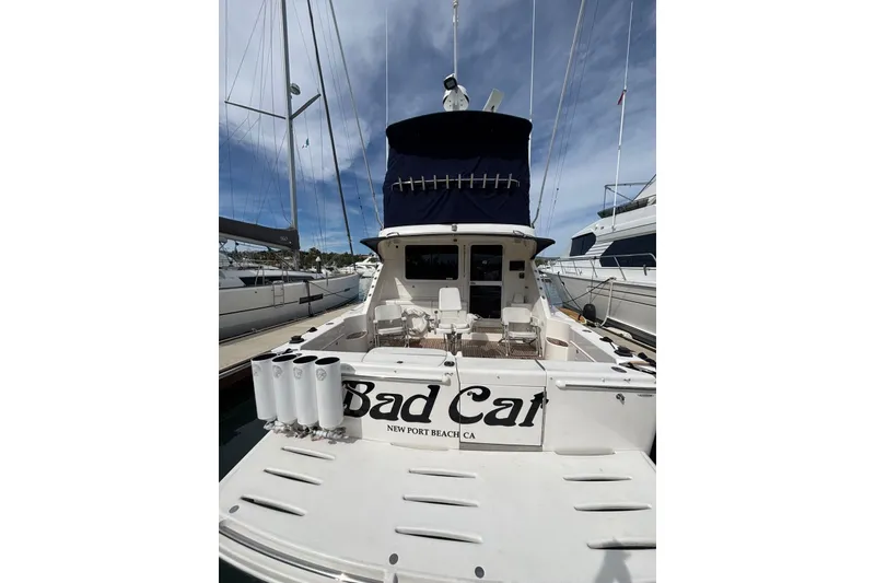 Slide: The Image of 2007 Riviera 51 Enclosed Flybridge yacht docked, rear view with "Bad Cat" name visible. - 20