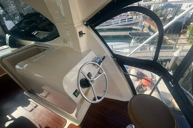 Slide: The Image of 2007 Riviera 51 Enclosed Flybridge helm with steering wheel and marina view. - 18