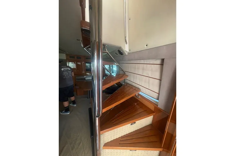 Slide: The Image of Interior staircase of 2007 Riviera 51 Enclosed Flybridge yacht with wooden steps and metal railing. - 22