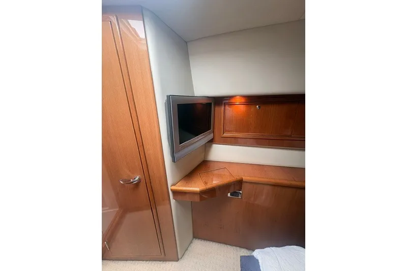 Slide: The Image of Interior of 2007 Riviera 51 Enclosed Flybridge with wood cabinetry and mounted TV. - 30