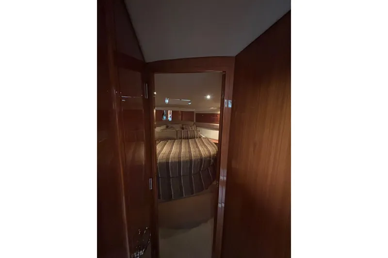 Slide: The Image of Interior view of 2007 Riviera 51 Enclosed Flybridge bedroom with striped bedding. - 17