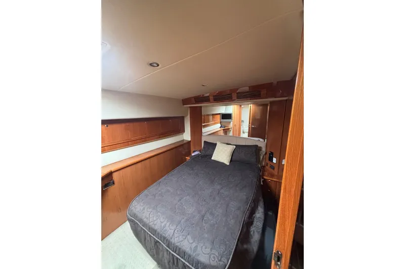 Slide: The Image of Luxurious bedroom interior of 2007 Riviera 51 Enclosed Flybridge yacht with elegant wood finishes. - 15