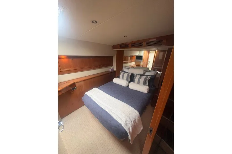 Slide: The Image of Luxurious bedroom interior of 2007 Riviera 51 Enclosed Flybridge yacht with cozy bedding. - 25