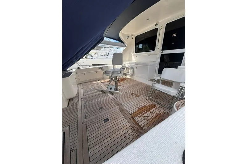Slide: The Image of 2007 Riviera 51 Enclosed Flybridge yacht deck with seating and wooden flooring. - 18