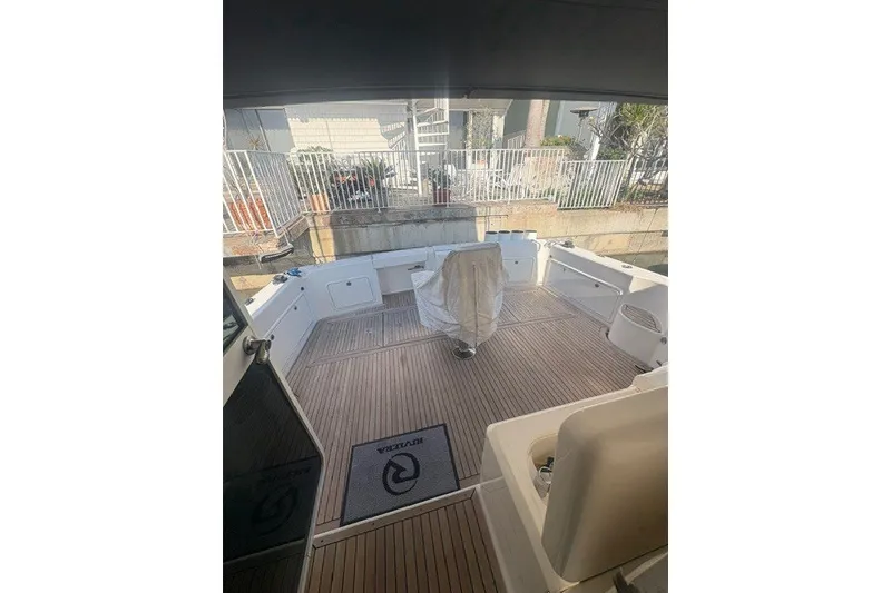Slide: The Image of 2007 Riviera 51 Enclosed Flybridge yacht deck with seating and covered chair. - 35