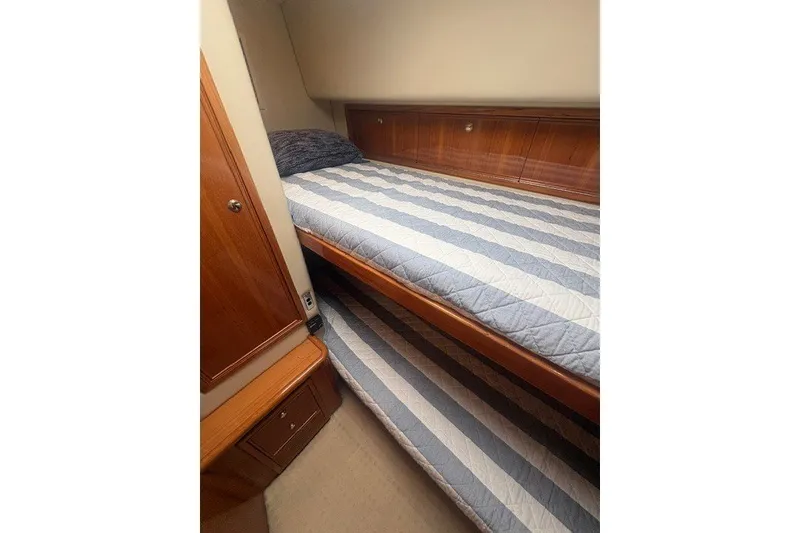 Slide: The Image of Interior of 2007 Riviera 51 Enclosed Flybridge with bunk beds and wooden cabinetry. - 23