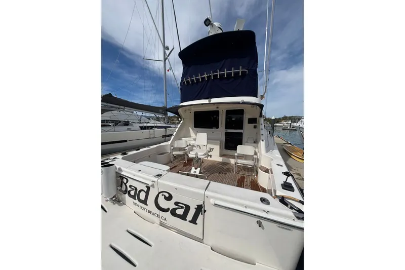 Slide: The Image of 2007 Riviera 51 Enclosed Flybridge yacht docked, featuring spacious deck and seating area. - 19