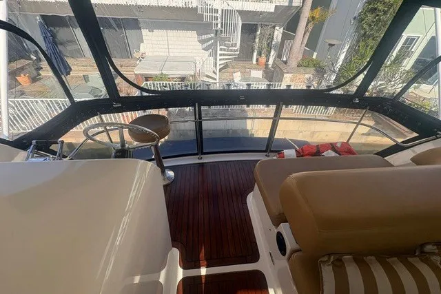 Slide: The Image of 2007 Riviera 51 Enclosed Flybridge interior with wooden flooring and seating area. - 19