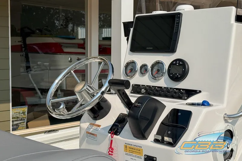 Slide: The Image of 2022 Avid 23 FS boat dashboard with steering wheel and navigation controls. - 20