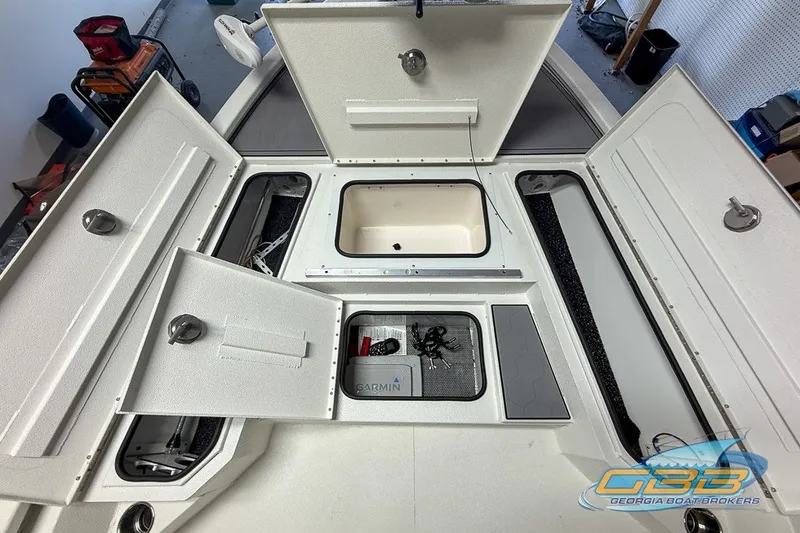 Slide: The Image of 2022 Avid 23 FS boat storage compartments open, showcasing organized interior space. - 14