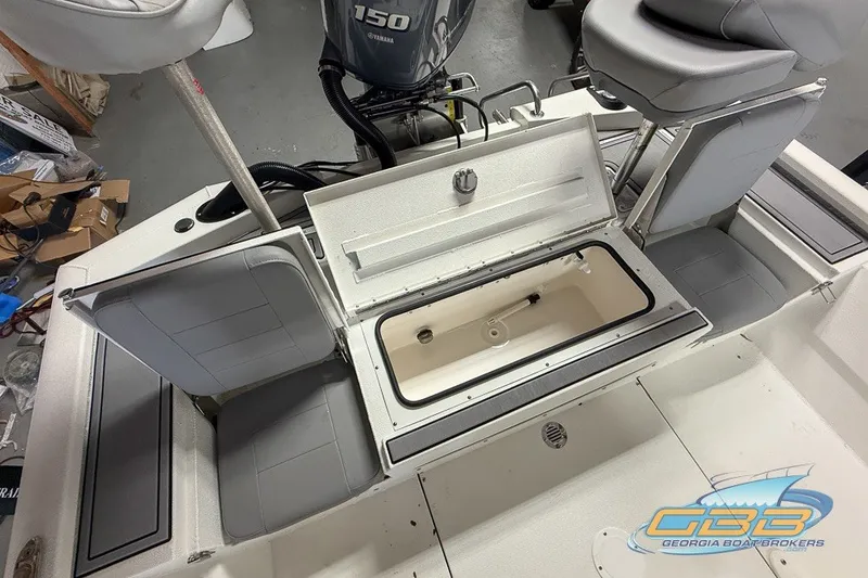 Slide: The Image of 2022 Avid 23 FS boat interior with open storage compartments and Yamaha 150 engine. - 15