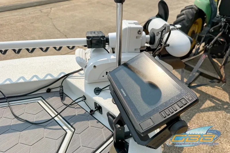 Slide: The Image of Avid 23 FS 2022 boat with Garmin navigation system and trolling motor, docked outdoors. - 7