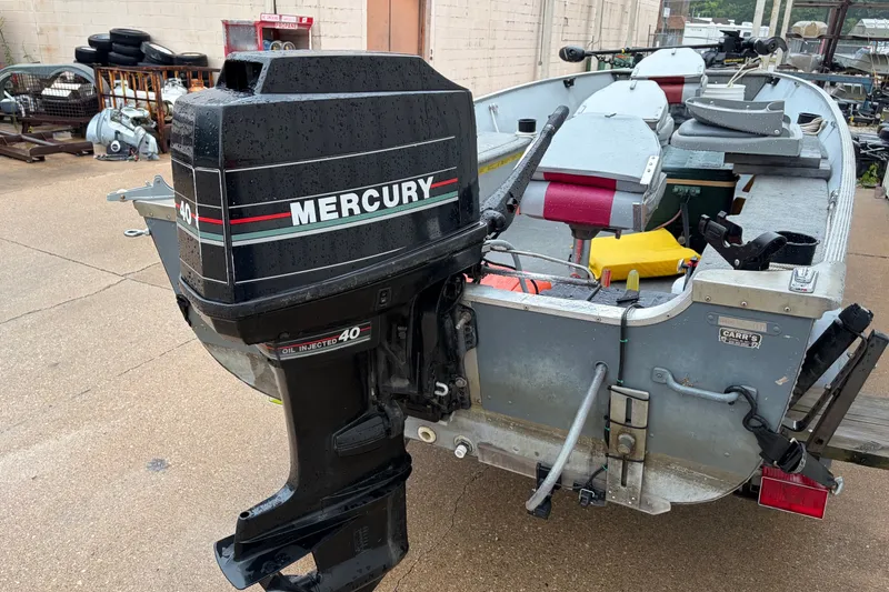 Slide: The Image of 1989 Lund 16 Pike SS boat with Mercury 40 outboard motor, parked outdoors. - 9