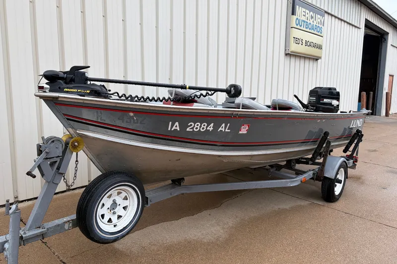 Slide: The Image of 1989 Lund 16 Pike SS fishing boat on trailer, parked outside Mercury Outboards shop. - 2