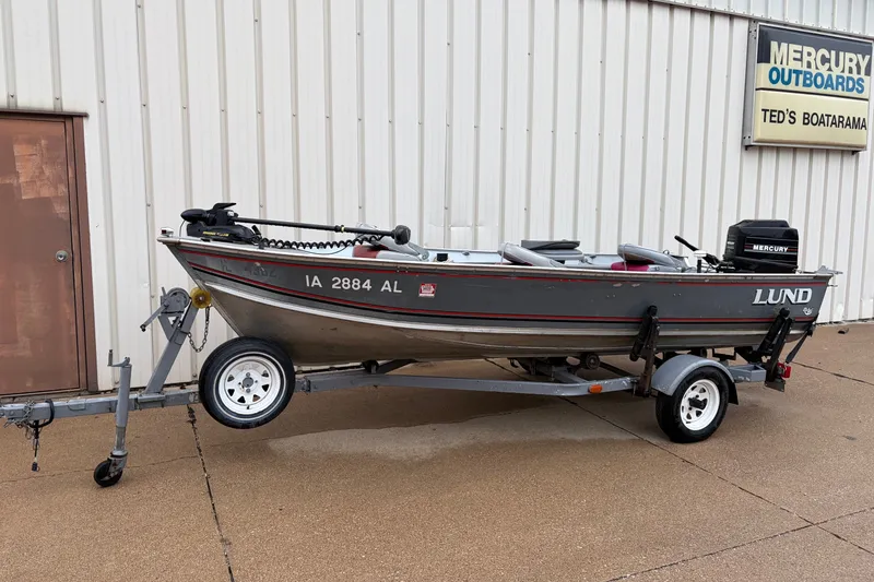 The Image of 1989 Lund 16 Pike SS fishing boat on trailer, parked outside Ted's Boatarama. - 0