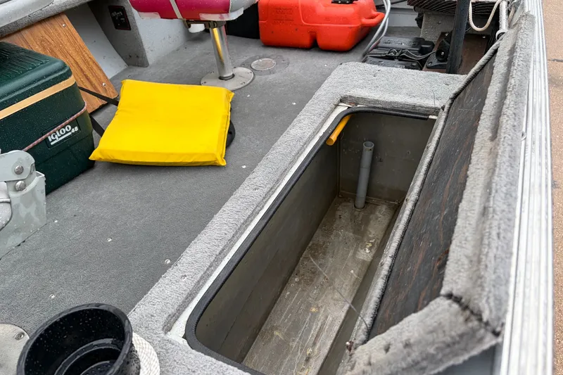 Slide: The Image of 1989 Lund 16 Pike SS boat interior with storage compartment, cooler, and safety equipment. - 5