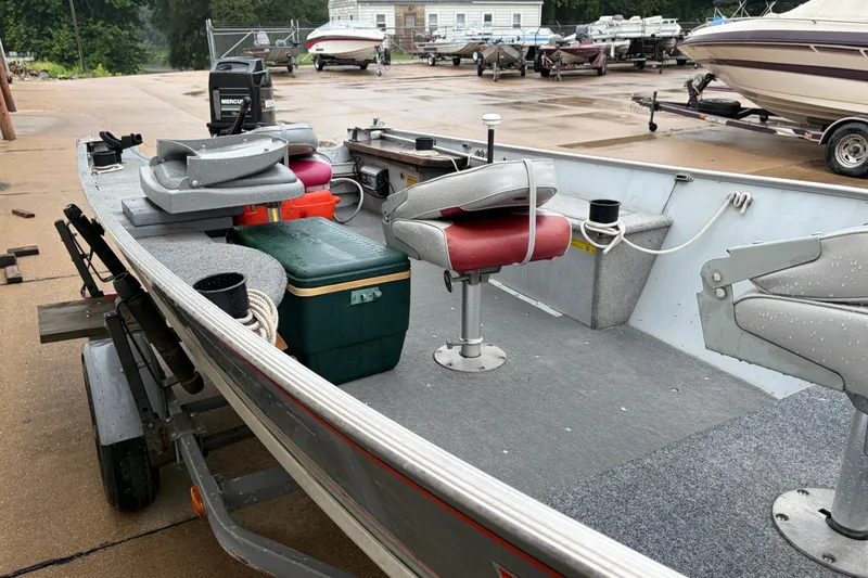 Slide: The Image of 1989 Lund 16 Pike SS boat with red seats and green cooler on a trailer. - 8