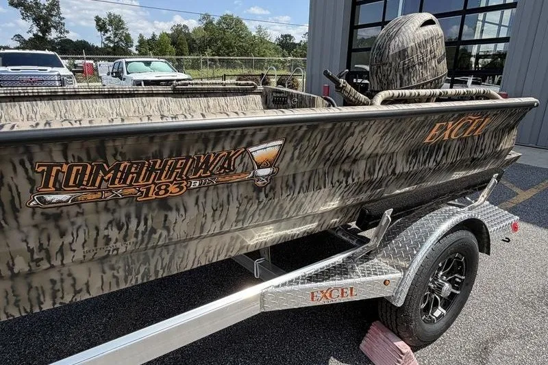 Slide: The Image of 2027 Excel 183 Tomahawk boat with camouflage design on a trailer. - 2