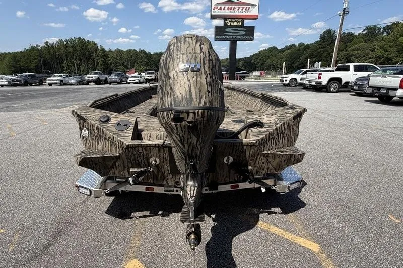 Slide: The Image of 2027 Excel 183 Tomahawk boat with camouflage design in a parking lot. - 7