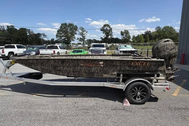 Slide: The Image of 2027 Excel 183 Tomahawk boat on trailer, parked outdoors under clear sky. - 5