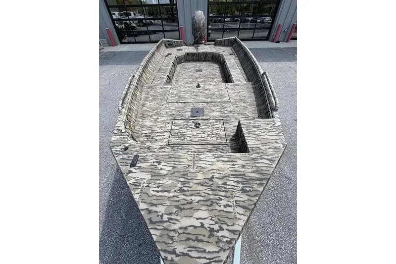 Slide: The Image of 2027 Excel 183 Tomahawk boat with camouflage design, parked outdoors. - 10
