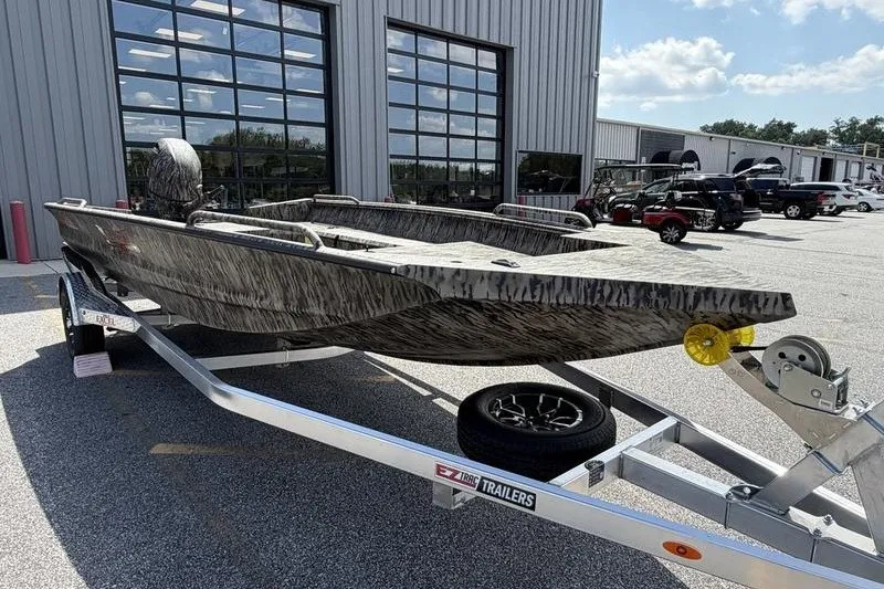 Slide: The Image of 2027 Excel 183 Tomahawk boat on trailer outside dealership, sunny day. - 16