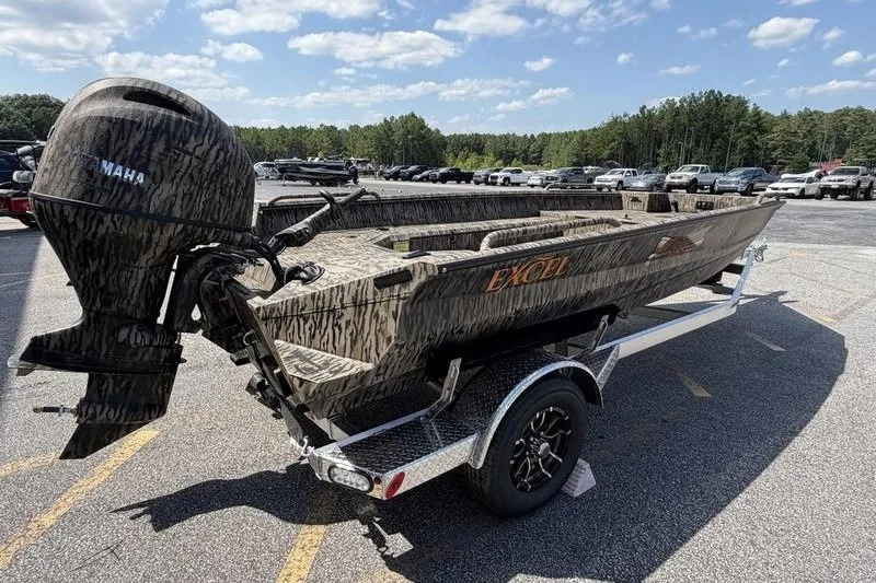 Slide: The Image of 2027 Excel 183 Tomahawk boat with camouflage design on a trailer in a parking lot. - 15