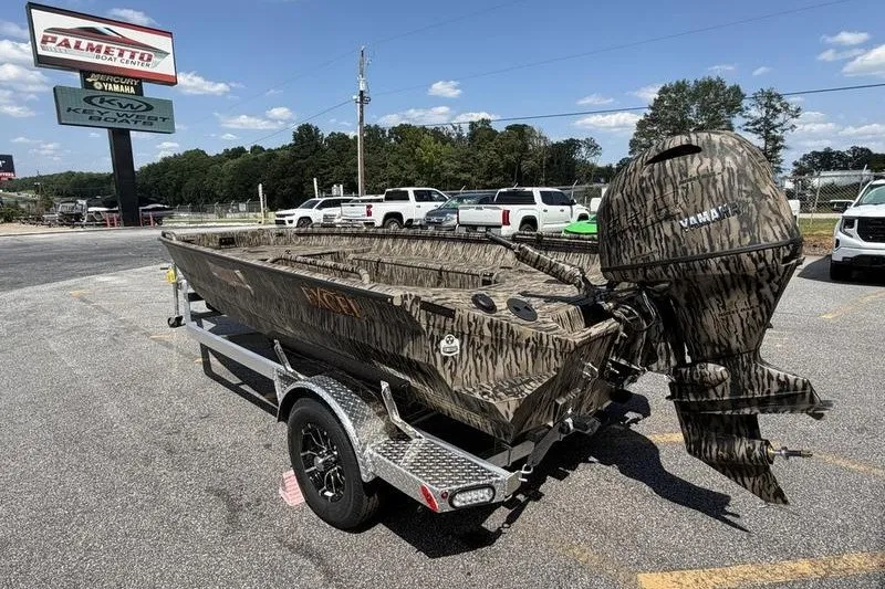 Slide: The Image of 2027 Excel 183 Tomahawk boat with camouflage design on a trailer in a parking lot. - 3
