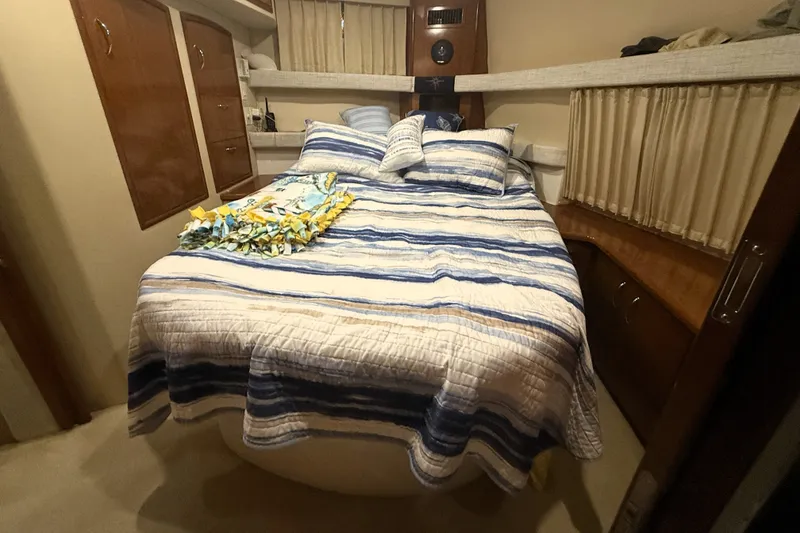 Slide: The Image of Cozy bedroom in 2003 Carver 366 Motor Yacht with striped bedding and wooden cabinetry. - 17