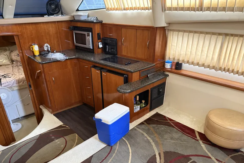 Slide: The Image of Interior of 2003 Carver 366 Motor Yacht with kitchenette and cozy seating area. - 13
