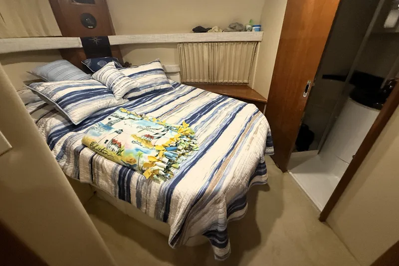 Slide: The Image of Cozy bedroom in 2003 Carver 366 Motor Yacht with striped bedding and adjacent bathroom. - 16