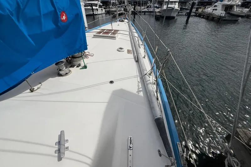 Slide: The Image of 1974 Spencer 53 sailboat deck with blue cover, docked at marina. - 2