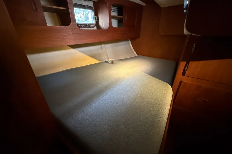 Slide: The Image of Cozy cabin interior of a 1974 Spencer 53 sailboat with wooden furnishings and a comfortable bed. - 28