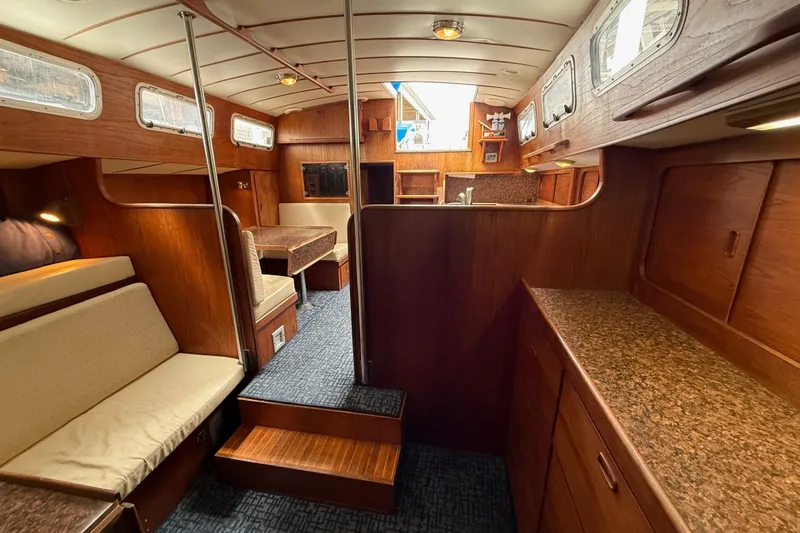 Slide: The Image of Interior of a 1974 Spencer 53 yacht, featuring wood paneling and cozy seating. - 26