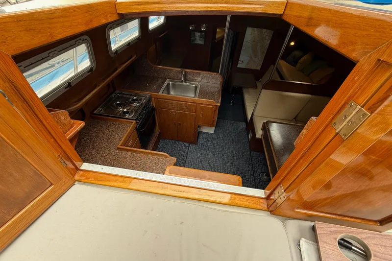 Slide: The Image of Interior of a 1974 Spencer 53 sailboat featuring a compact kitchen and cozy seating area. - 36