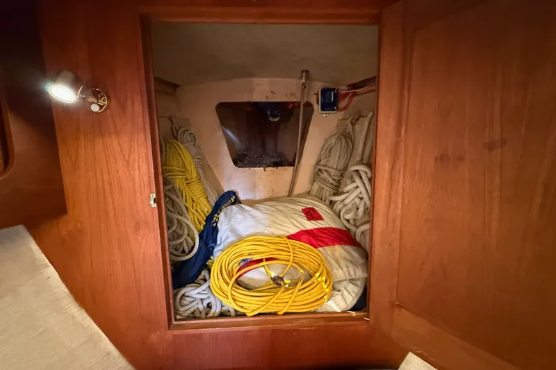 Slide: The Image of Storage compartment in a 1974 Spencer 53 sailboat, filled with ropes and equipment. - 38