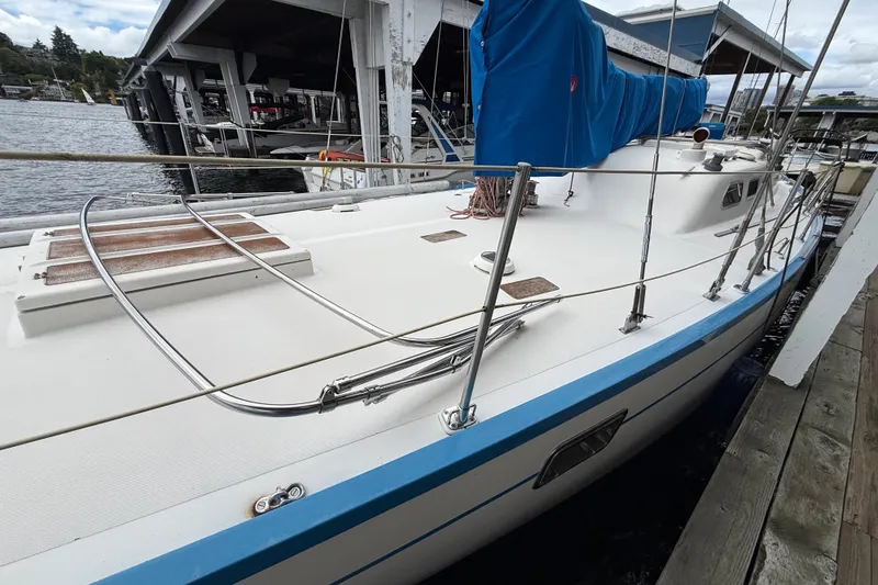 Slide: The Image of 1974 Spencer 53 sailboat docked, featuring a sleek white deck and blue sail cover. - 63