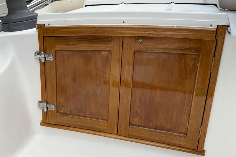 Slide: The Image of Wooden cabinet doors on a 1974 Spencer 53 boat, featuring metal hinges and a lock. - 54