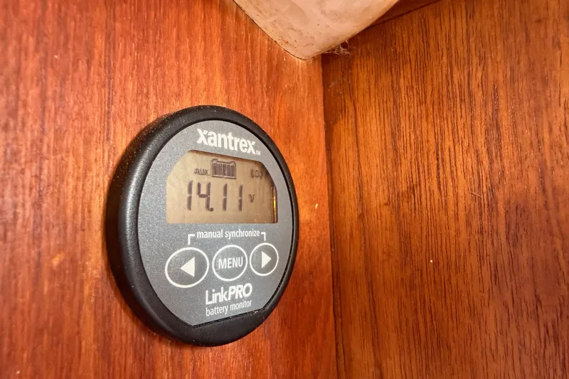 Slide: The Image of Xantrex LinkPRO battery monitor displaying 14.11 volts on a wooden panel. Spencer 53, 1974. - 49