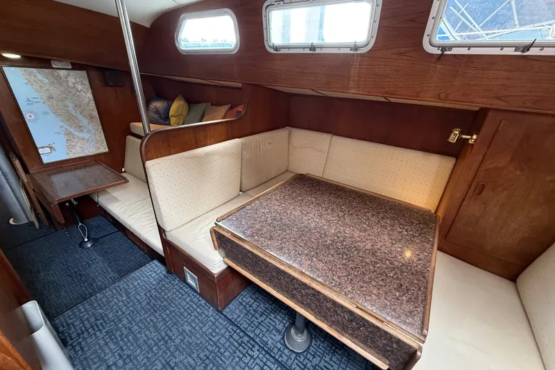 Slide: The Image of 1974 Spencer 53 yacht interior with cozy seating, wooden accents, and a navigation map. - 41
