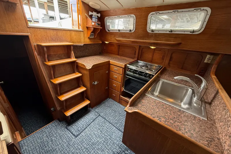 Slide: The Image of Vintage 1974 Spencer 53 yacht kitchen with wooden cabinetry, stove, and sink. - 9